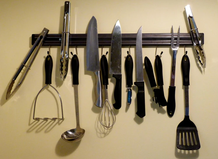 a number of utensils hanging on a wall