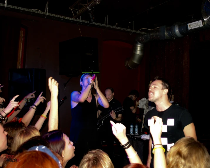 a group of people reaching up to someone on the stage