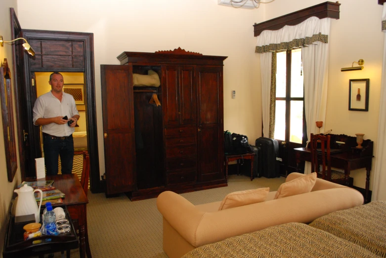 a man standing in his bedroom with furniture and closets