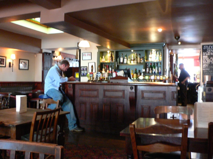 a bartender and a waitress standing behind a bar