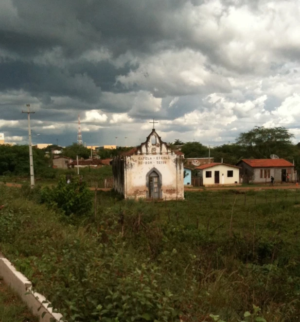 a church with a cross at the top under a cloudy sky