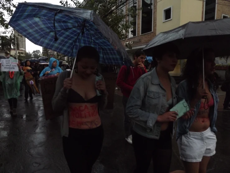 two women walking in the rain under an umbrella
