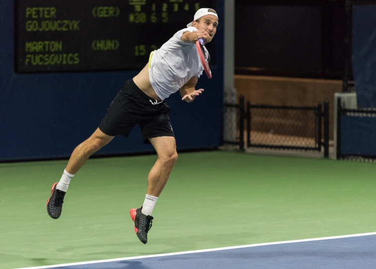 a man jumps up to hit a tennis ball