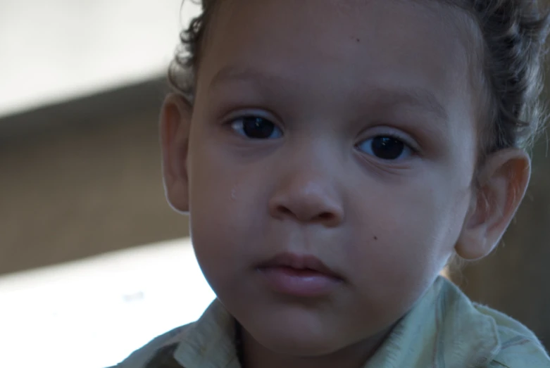 this toddler is looking at the camera and has very blue eyes