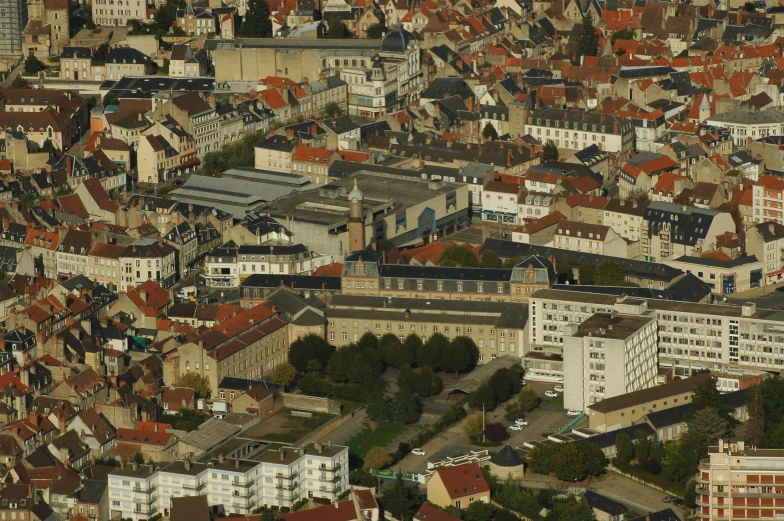 a very tall city with orange roofs and several buildings