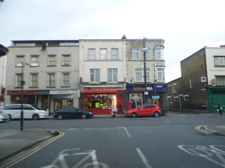 small businesses and cars sit on a city street