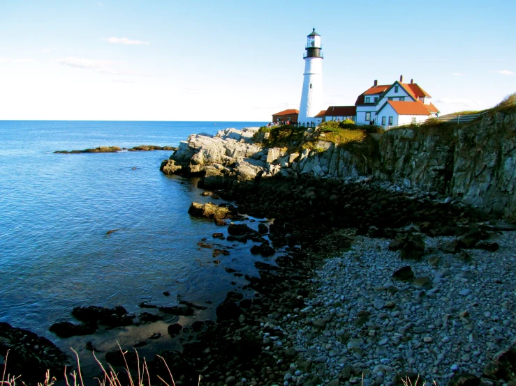 a light house sitting on top of a cliff by the ocean