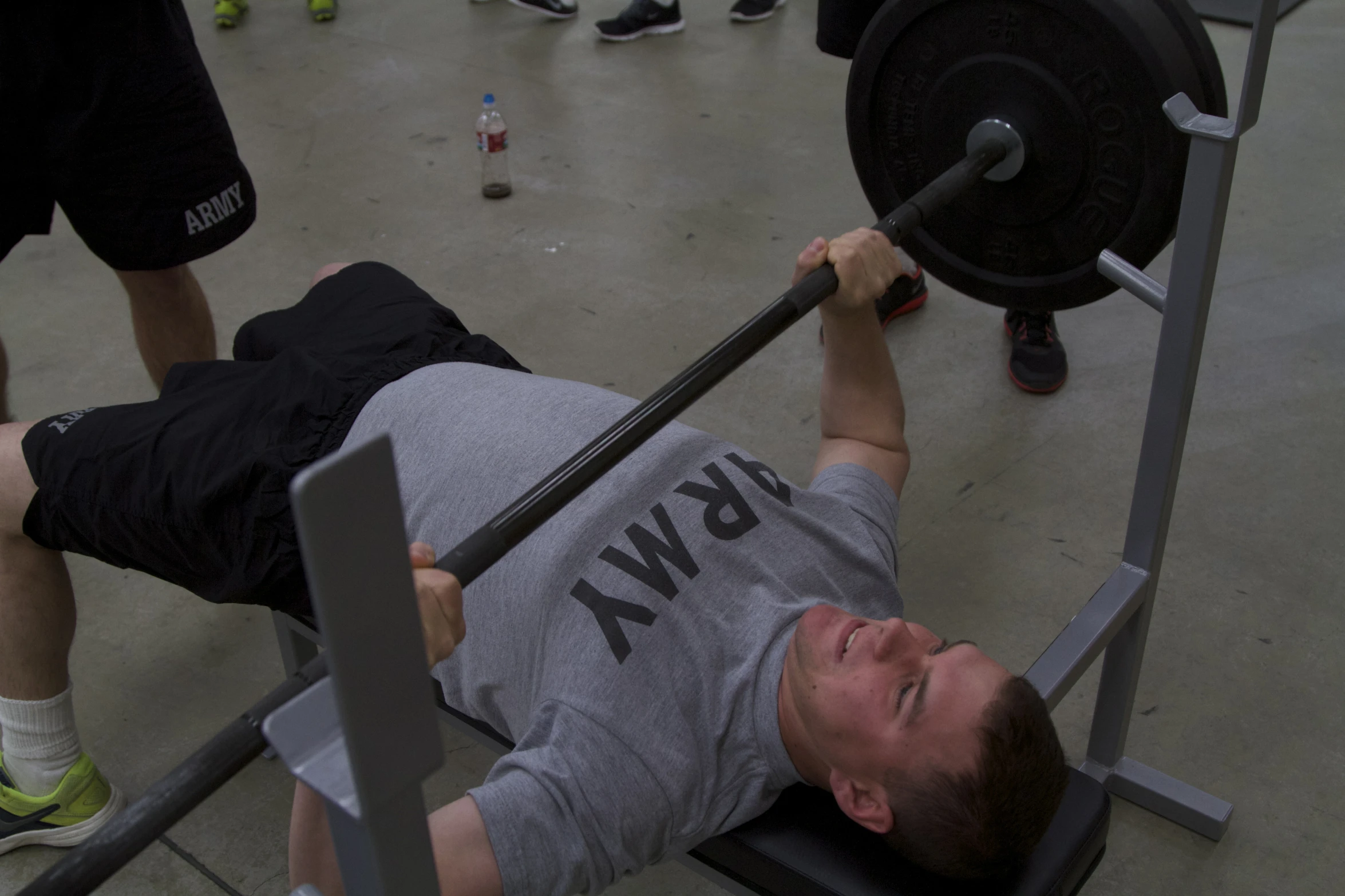 a man lies on the ground while lifting a barbell