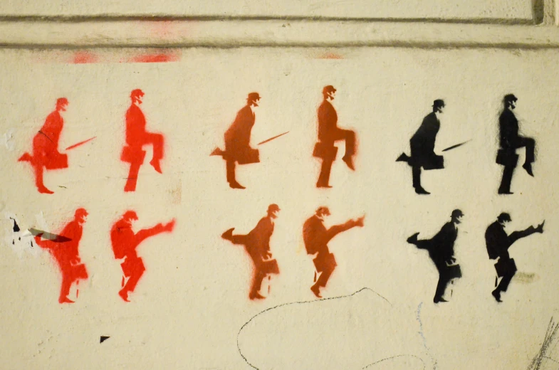 various silhouettes are drawn on a wall by some people