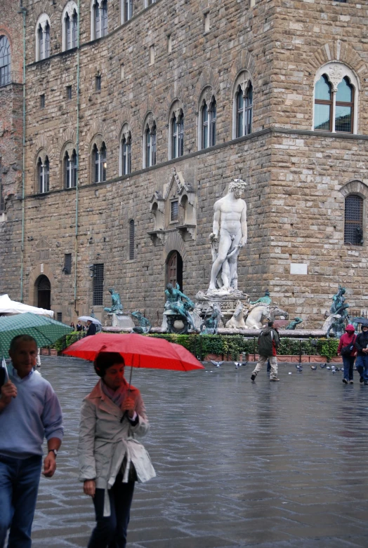 two people walking in the rain with open umbrellas