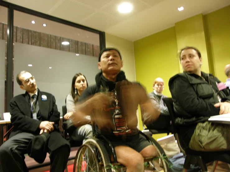 man in wheel chair in wheelchair being filmed by audience