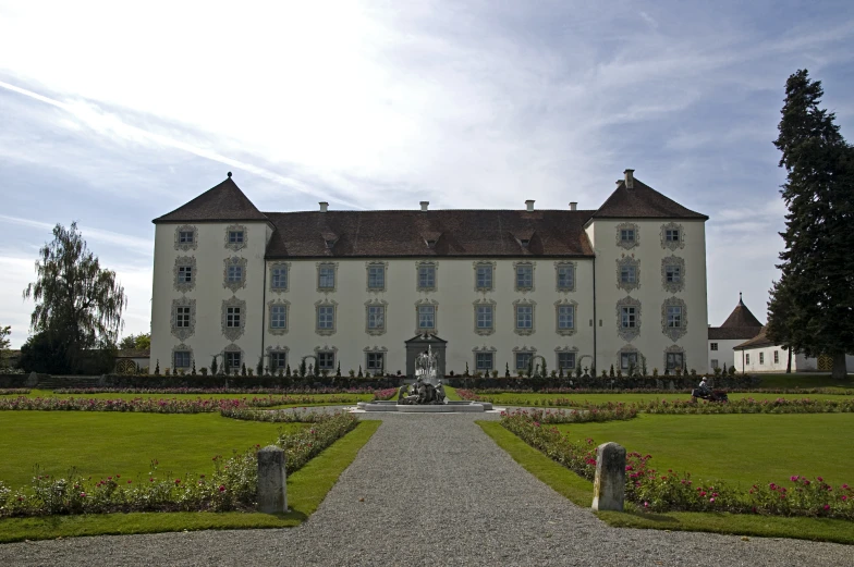 a big white house with some trees and a garden