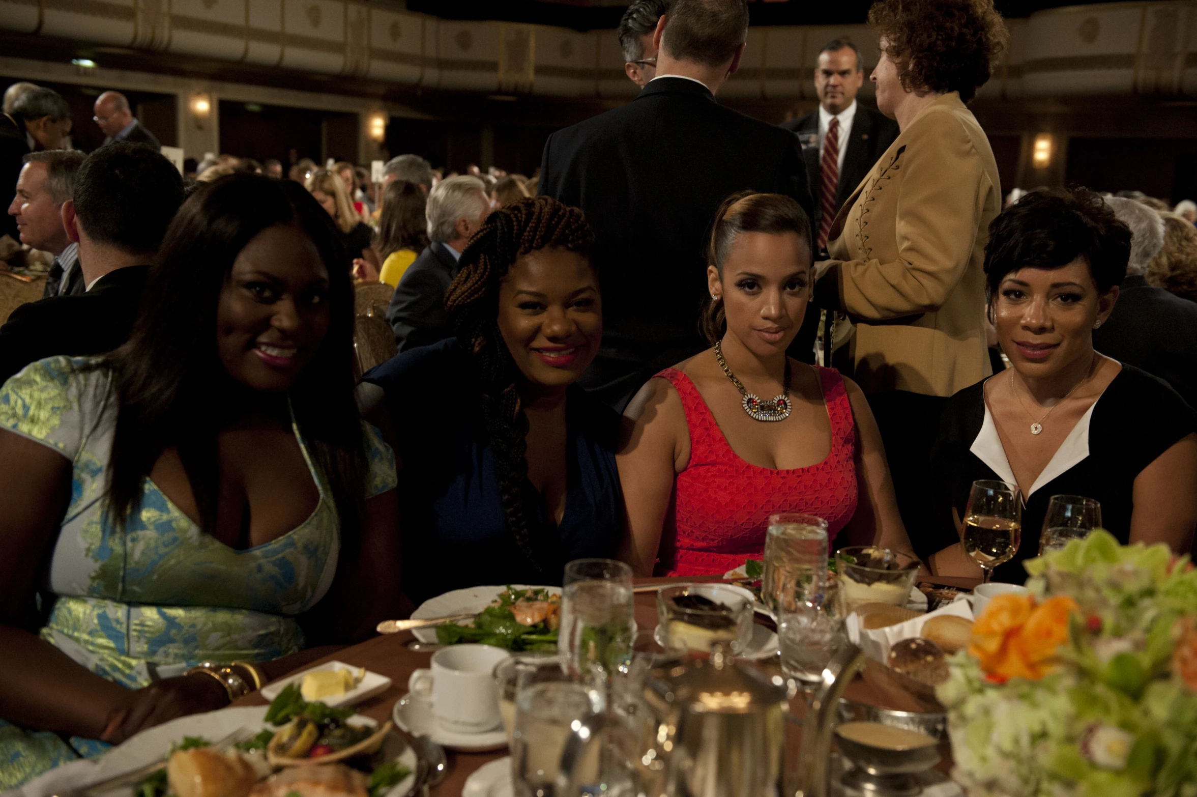 four women sitting around a table together at an event