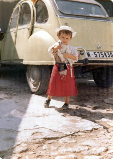 there is a little girl standing in front of a car