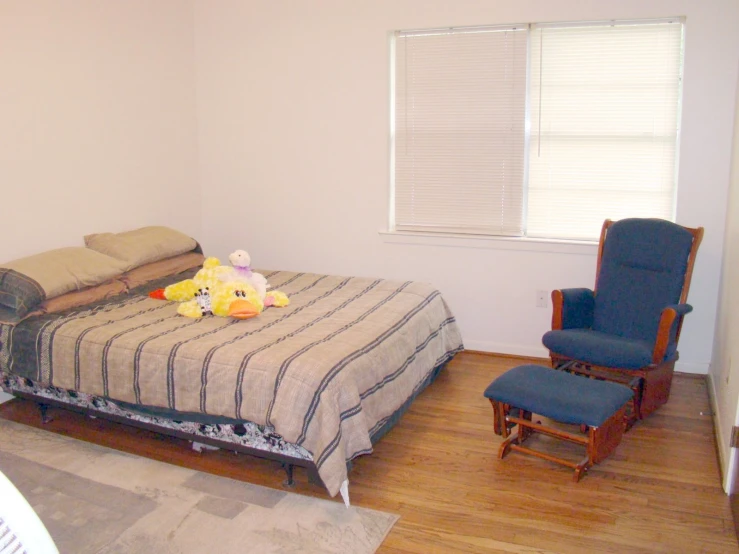 a single bed with a wooden headboard and arm rests on a hardwood floor