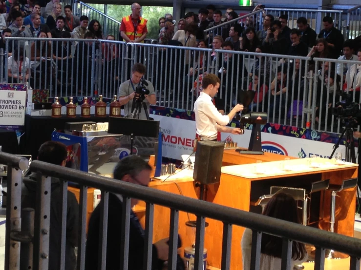 a person standing on a stage behind a fence