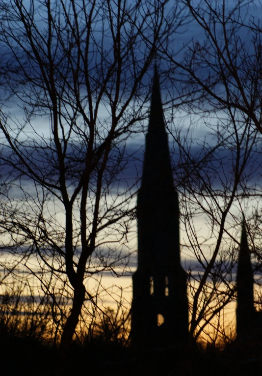 a large spire is silhouetted against a purple sky