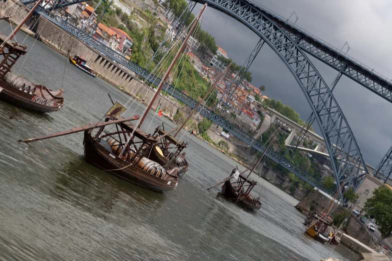 several wooden sailing boats out on the water