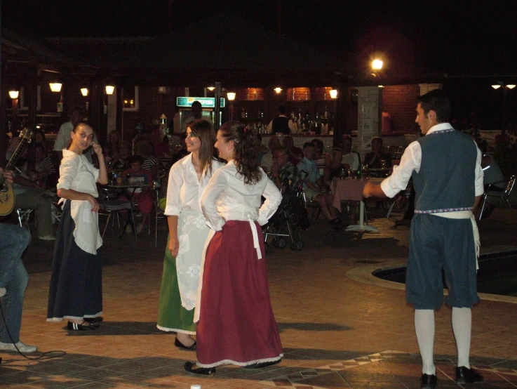 people in a dance performance are dressed in old clothing