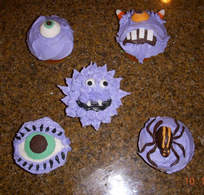 a plate with cupcakes decorated to look like monsters