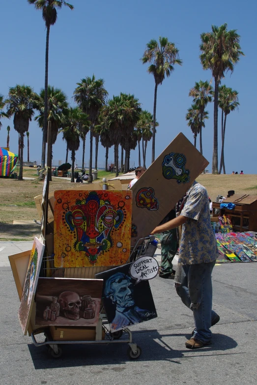 a person hing luggage in the street by palm trees