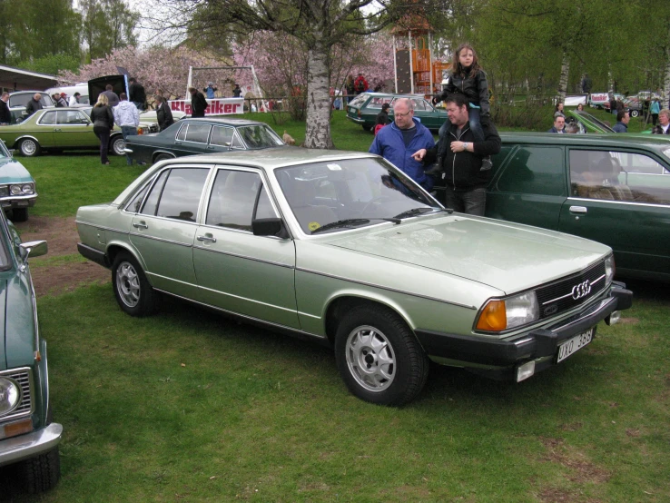 people look over the cars on display at an event