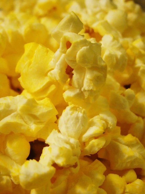 a big pile of yellow popcorn sitting in a bag