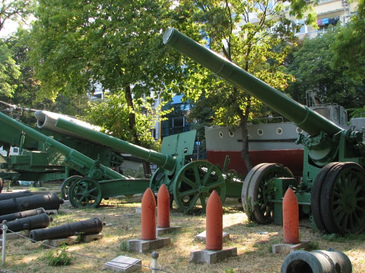 several large artillery cannon in a park setting