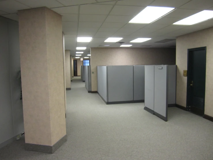 a room with multiple stalls and light colored walls