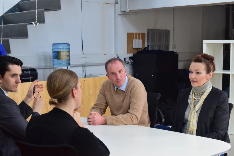 a group of people sitting around a table talking