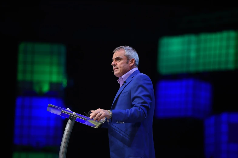 a man in a blue suit is making a speech