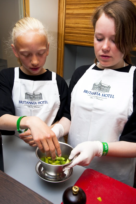 two girls are preparing food in the kitchen