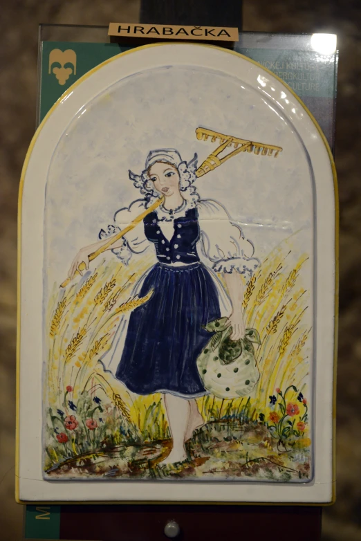 a tile painting of a woman in blue is displayed on a wall