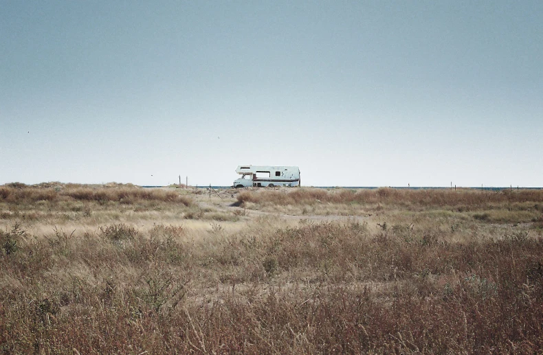 a truck and trailer are parked on a hill above a field