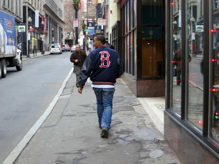 a man walking down a street while holding onto his bag