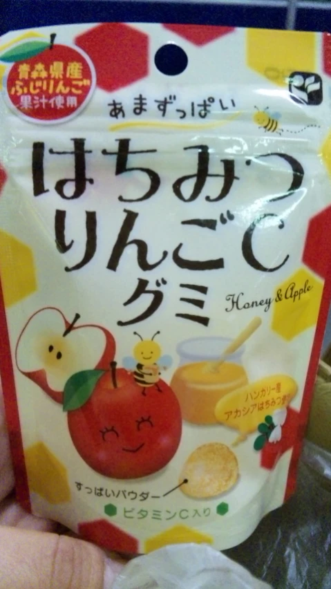 hand holding packet of various fruits and vegetables in front of a store display