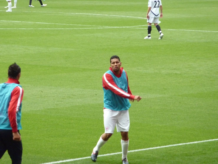 three men playing soccer on an outdoor field