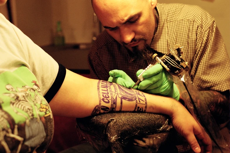 two people are getting their tattoos done at the same time