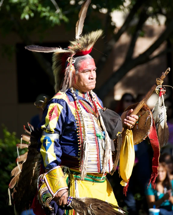 a person wearing a colorful head dress and feathers