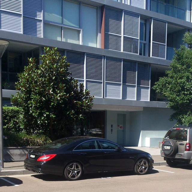 a car in the middle of a parking lot with an apartment building