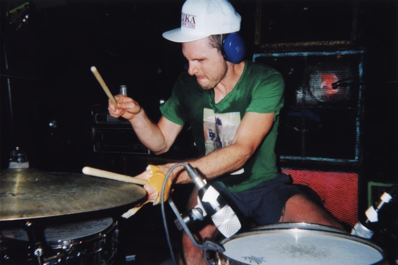 the man is sitting in a room playing drums