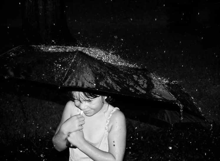 girl under an umbrella while it rains outside