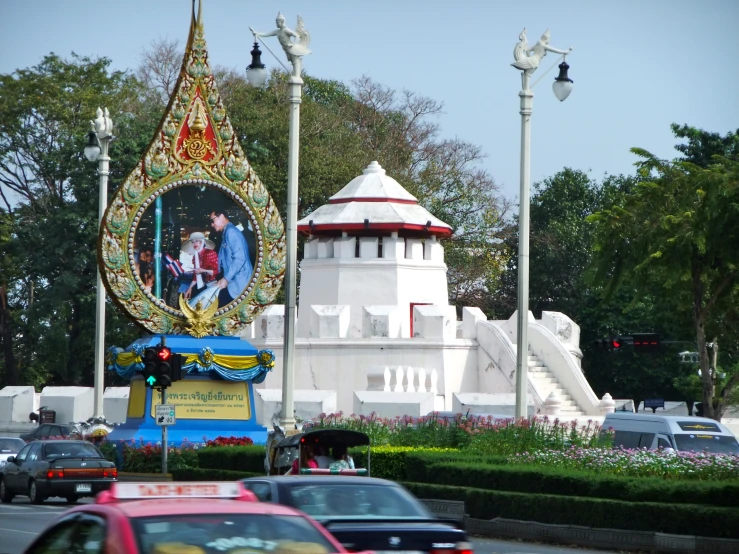 cars drive by an elaborately decorated building