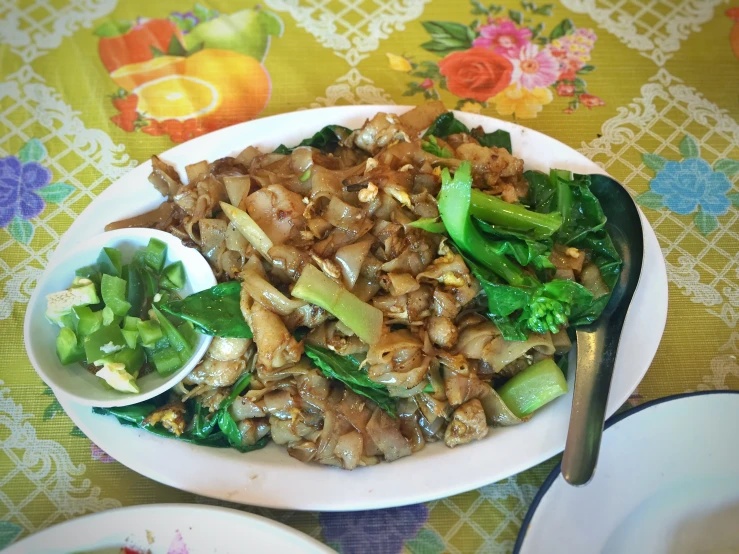 there is a plate full of food and spoons on a table