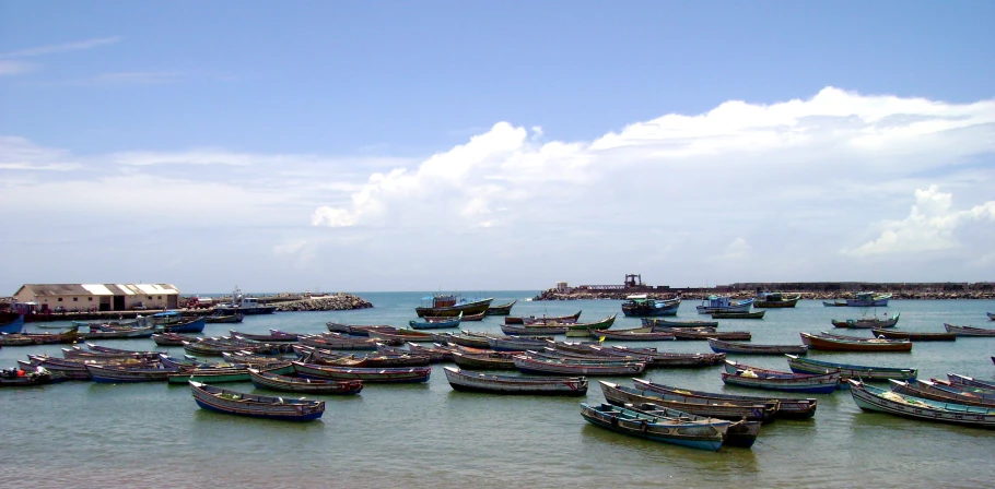 boats moored in the harbor under the cloudy blue sky