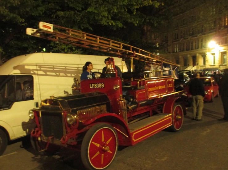 a group of people riding in an old - fashioned fire engine