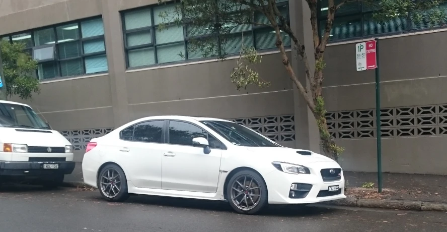 two white cars parked on the side of the street