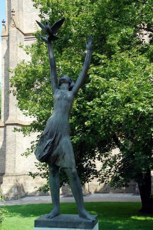 a statue on a grassy field near a building