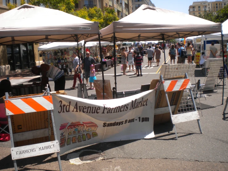 an outdoor flea market with a banner displayed next to it