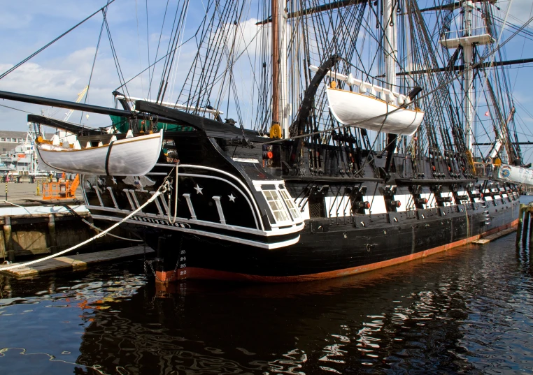 two large black ships moored at a dock